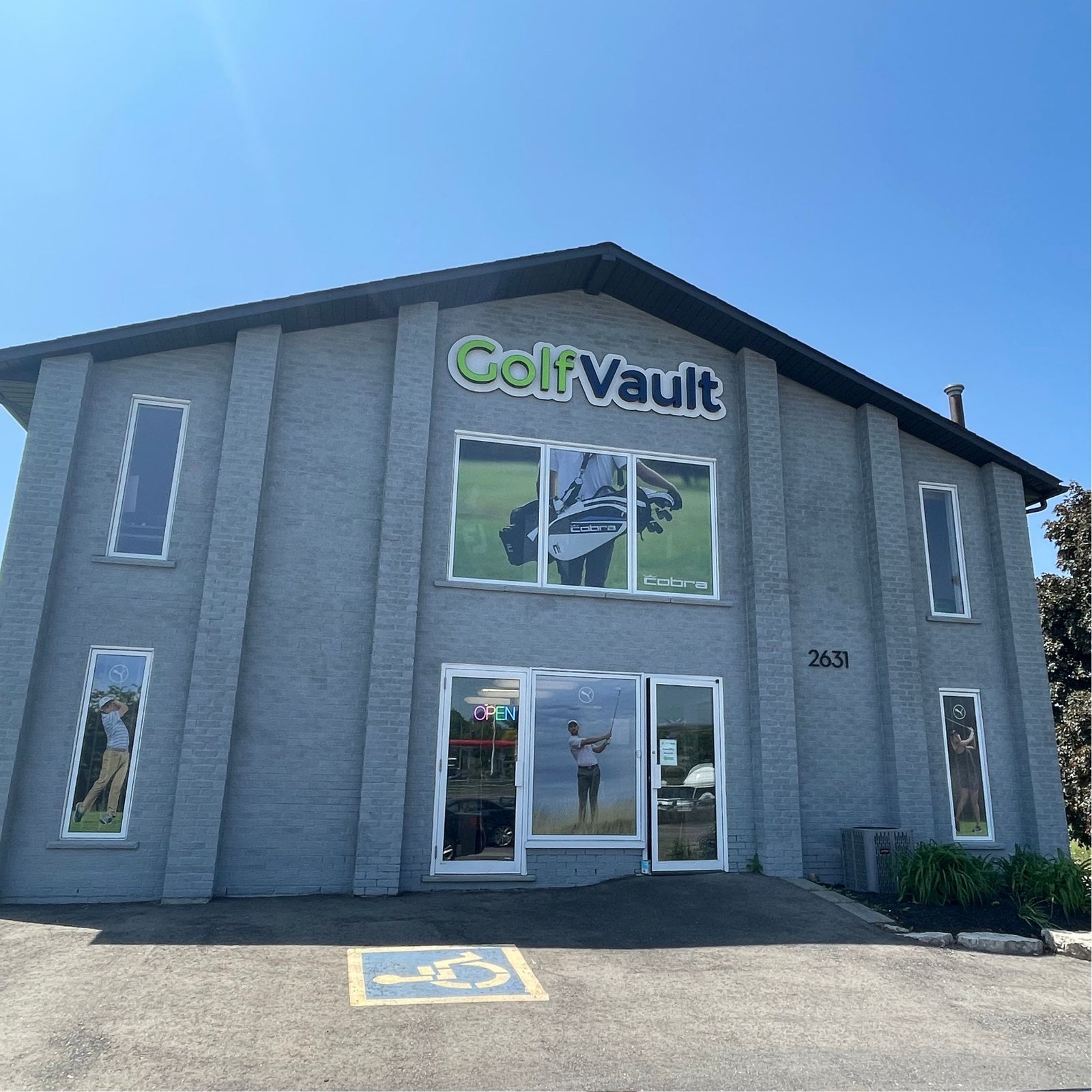 showing the entire front of Golf Vault's store front budling on a sunny day with blue skies